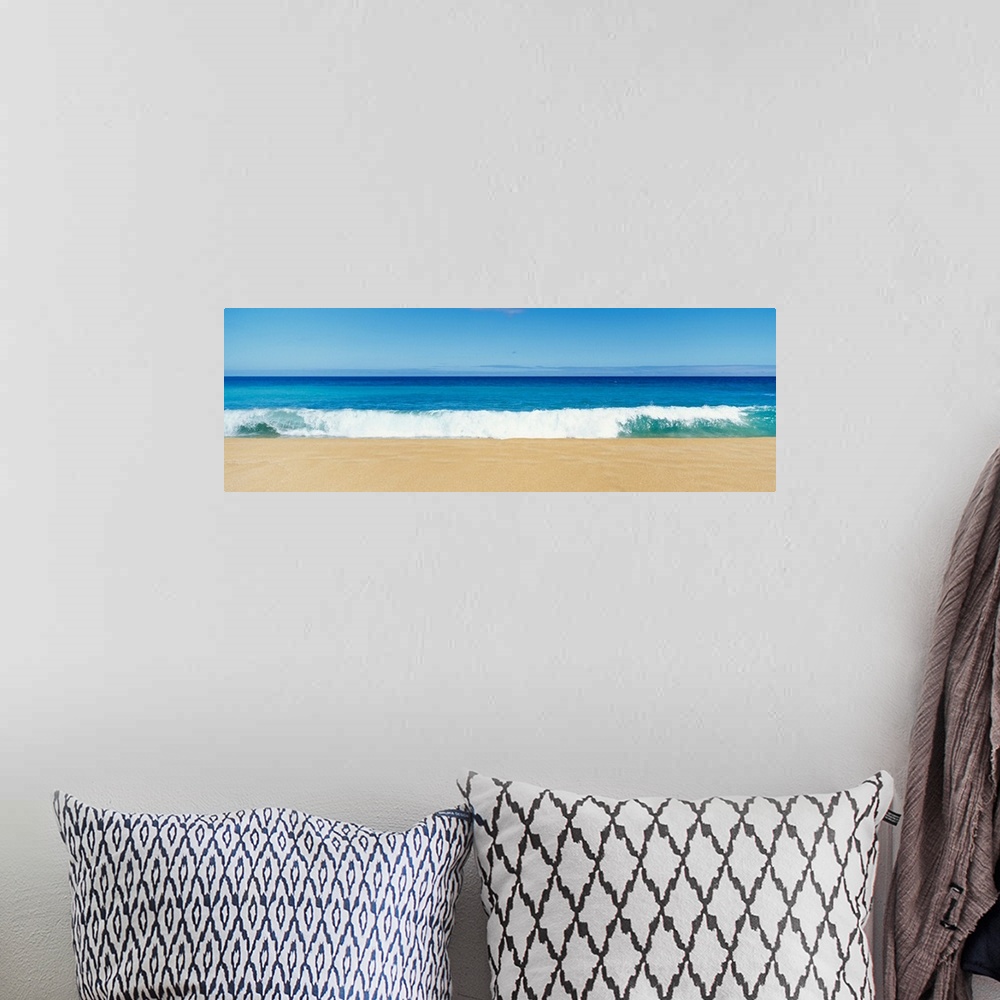 A bohemian room featuring This panoramic photograph captures a swell breaking on the sandy shore of a tropical beach on a c...