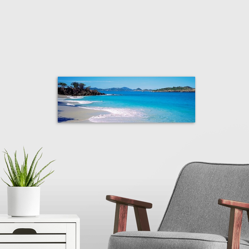 A modern room featuring Panoramic photograph displays the calm waters of this bay slowly crashing into the sandy beach, w...