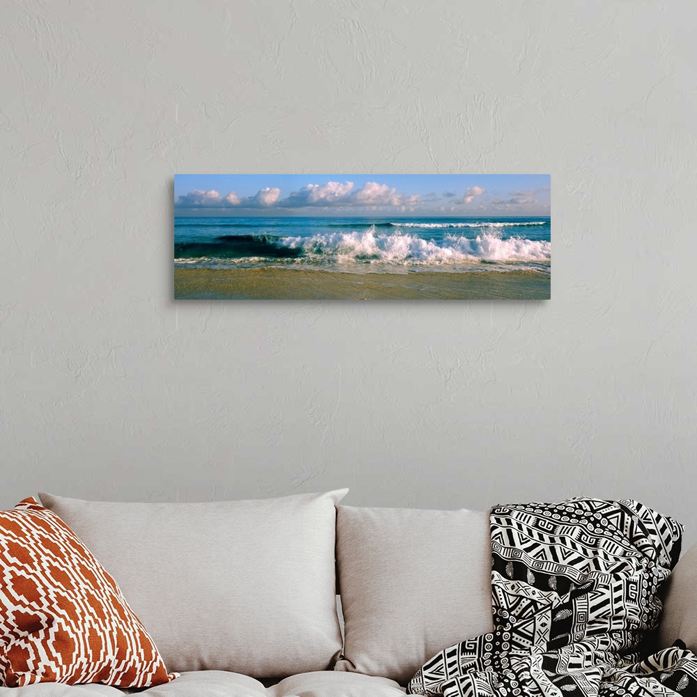 A bohemian room featuring Panoramic photograph of cloudy day at the beach with sea surf crashing onto the sand.