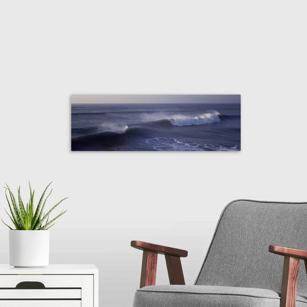 A modern room featuring Long horizontal photo on canvas of waves crashing in the Pacific Ocean.
