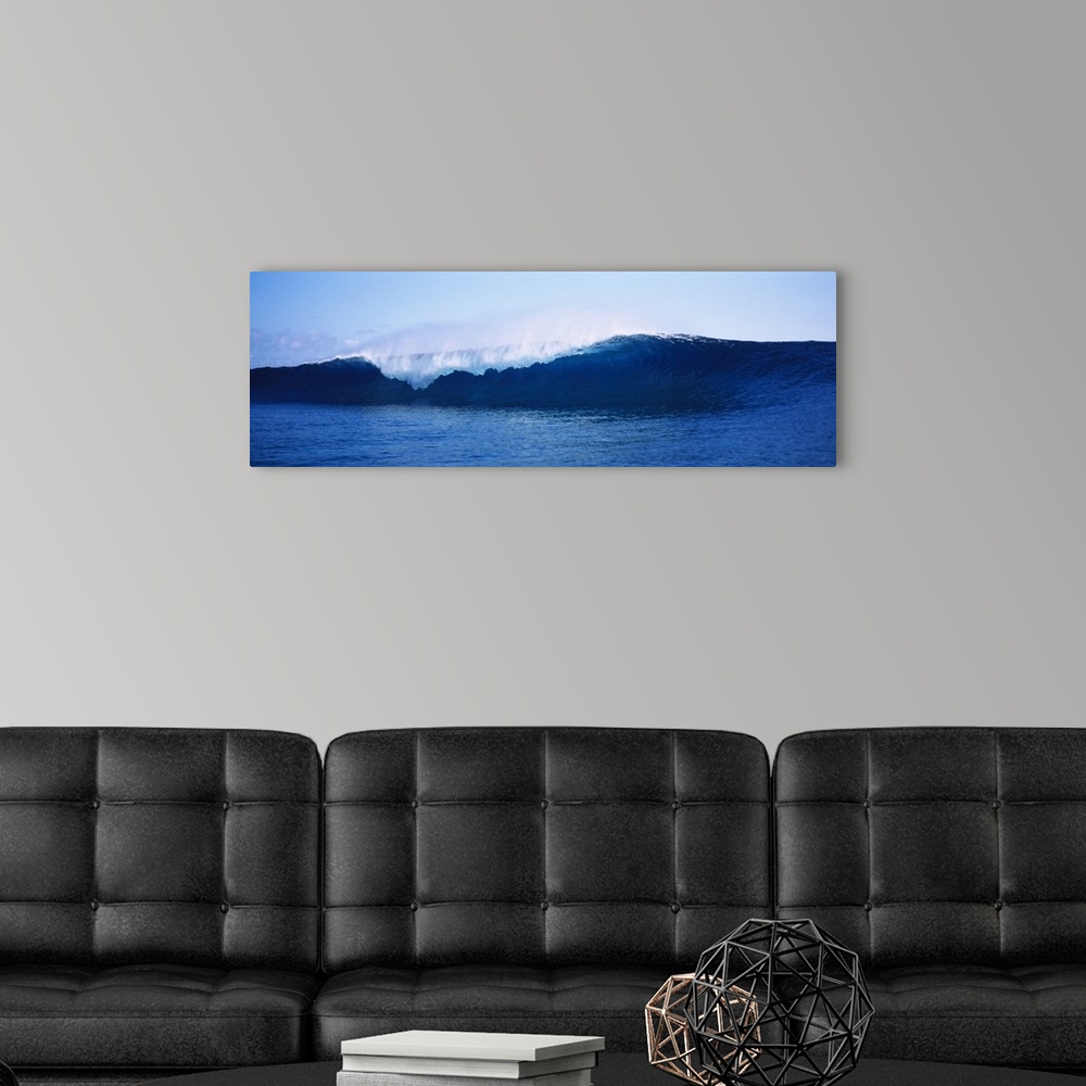 A modern room featuring Breaking wave about to crash in the sea with ocean spray flying off the crest under a clear blue ...