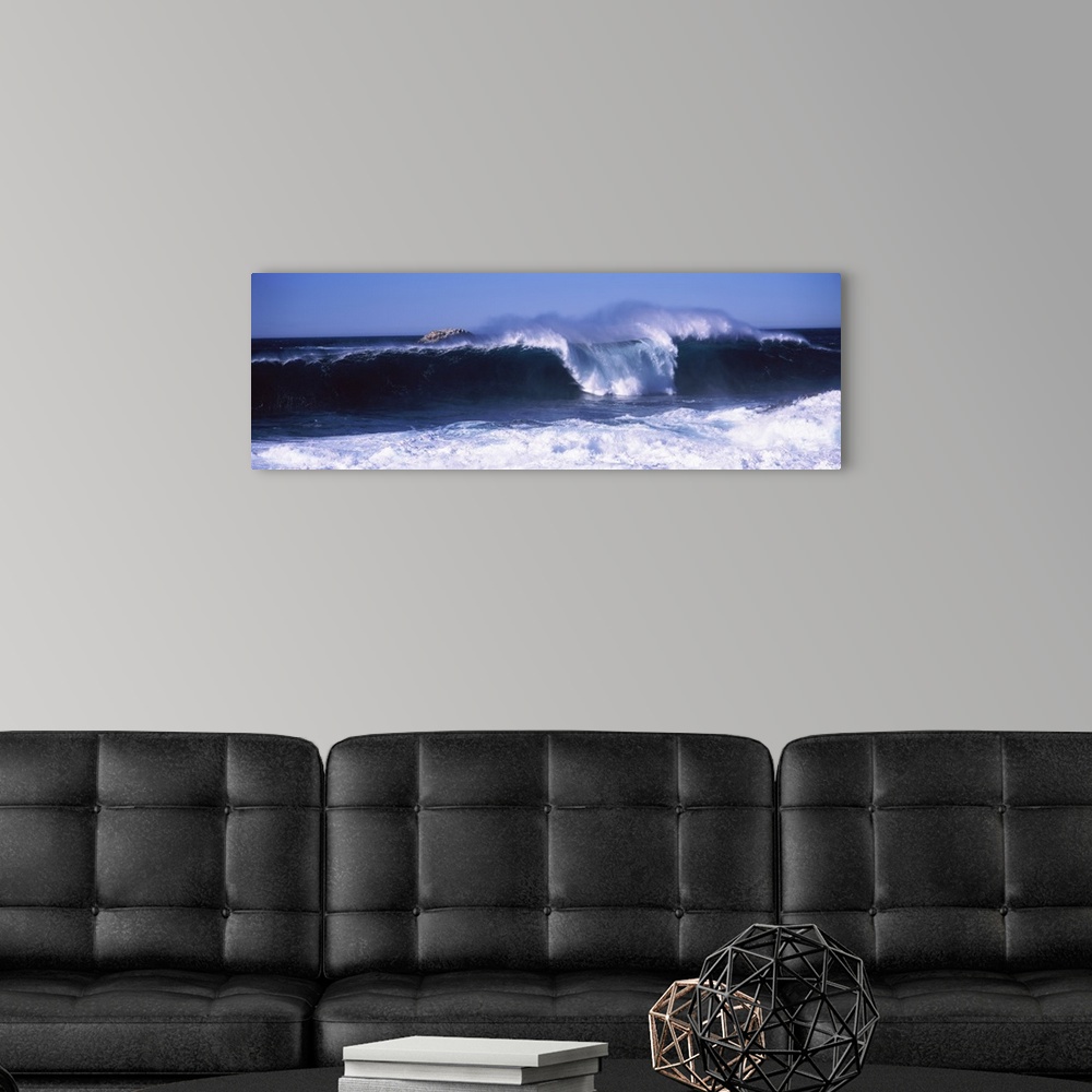 A modern room featuring This panoramic beach photograph captures a wave curling and breaking off the shore.