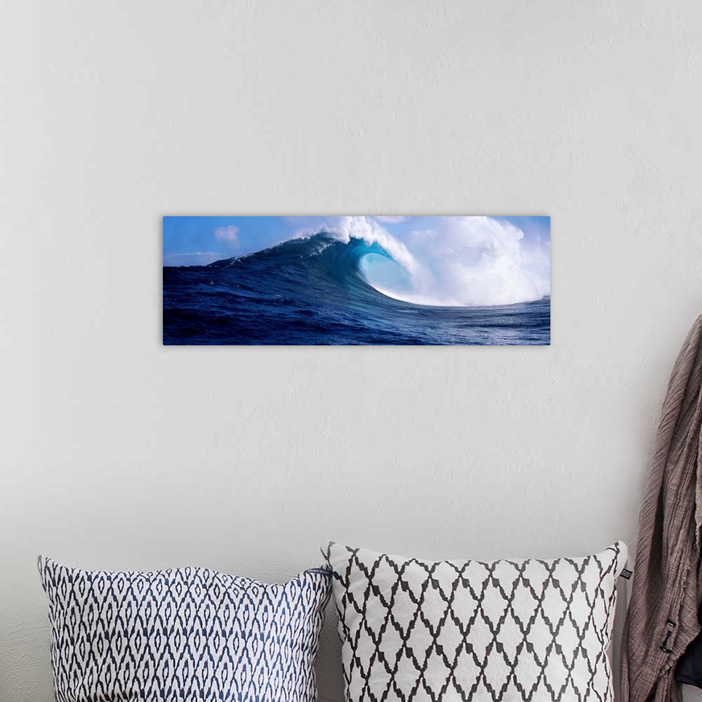 A bohemian room featuring A panoramic photograph capturing a plunging wave in motion as it prepares to break on the surface...