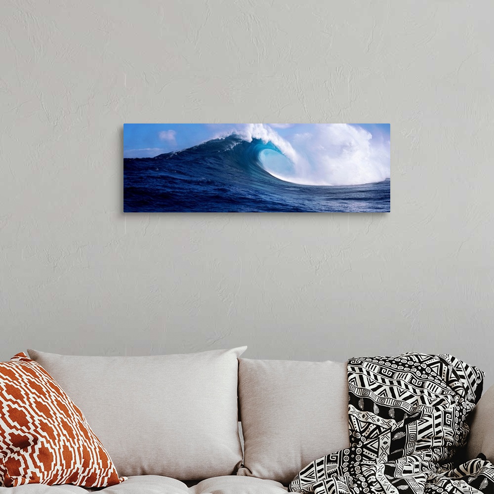 A bohemian room featuring A panoramic photograph capturing a plunging wave in motion as it prepares to break on the surface...