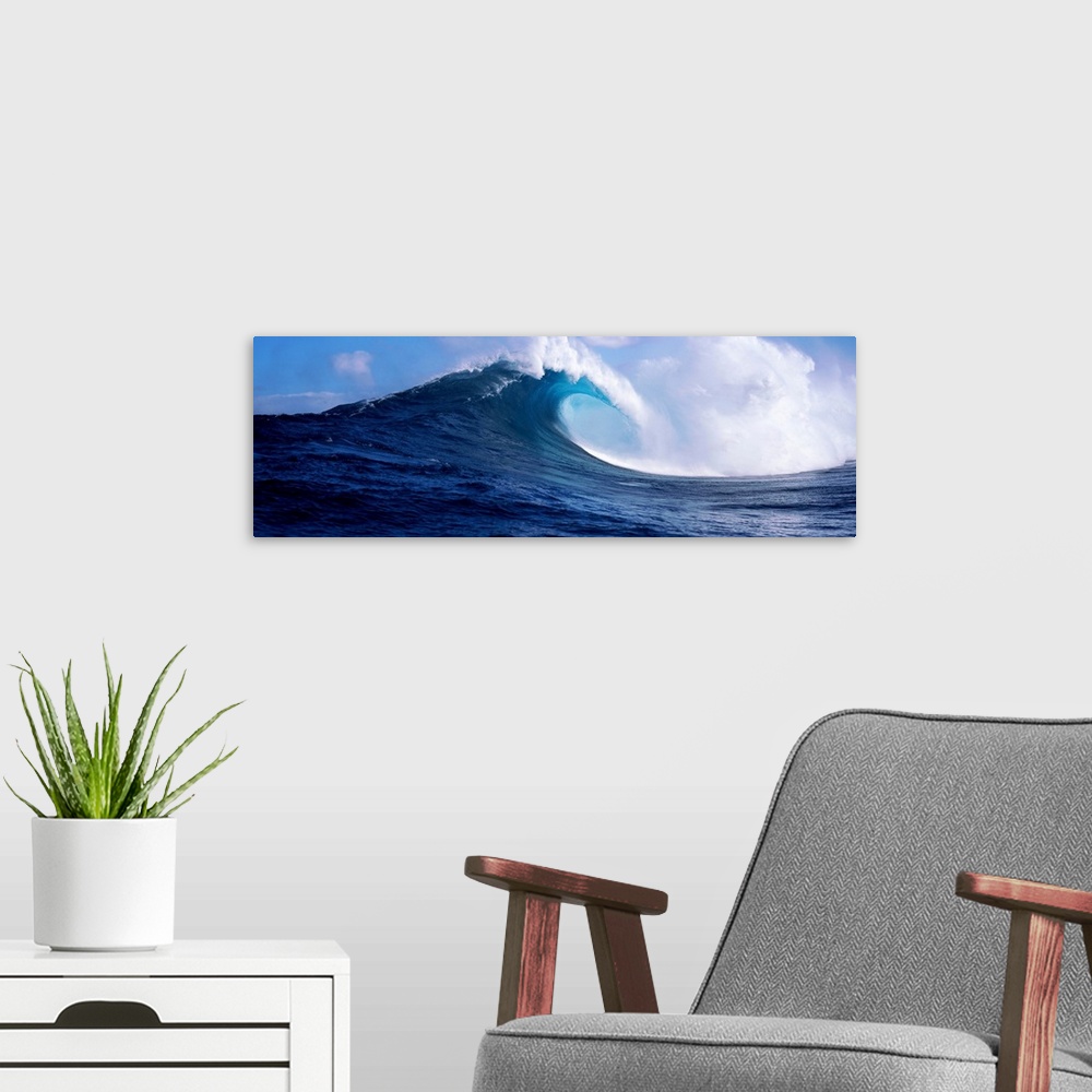 A modern room featuring A panoramic photograph capturing a plunging wave in motion as it prepares to break on the surface...