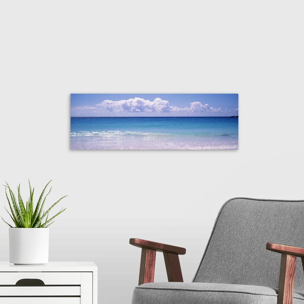 A modern room featuring Giant, landscape photograph of a shoreline in Vieques, Puerto Rico.  Small waves of clear blue wa...
