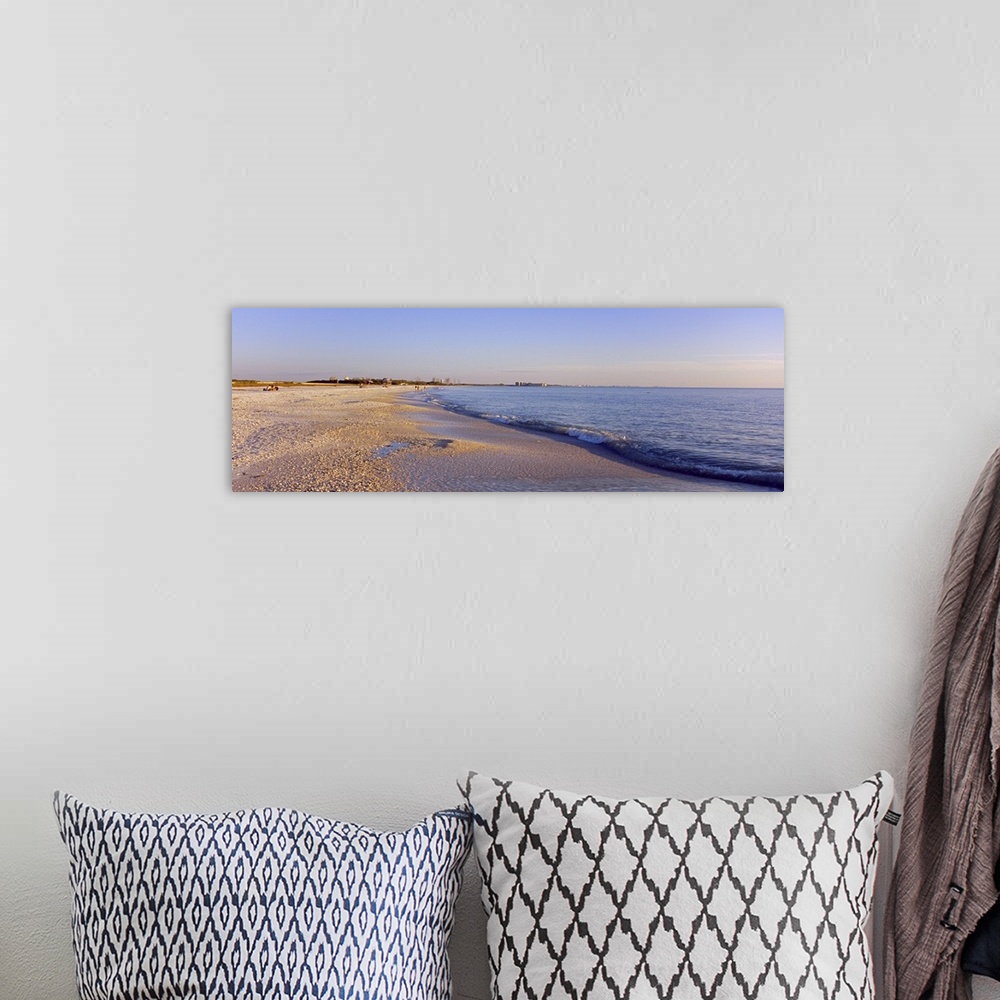A bohemian room featuring Panoramic photograph looking down the shoreline of Fort Myers Beach beneath a blue sky, in the Gu...