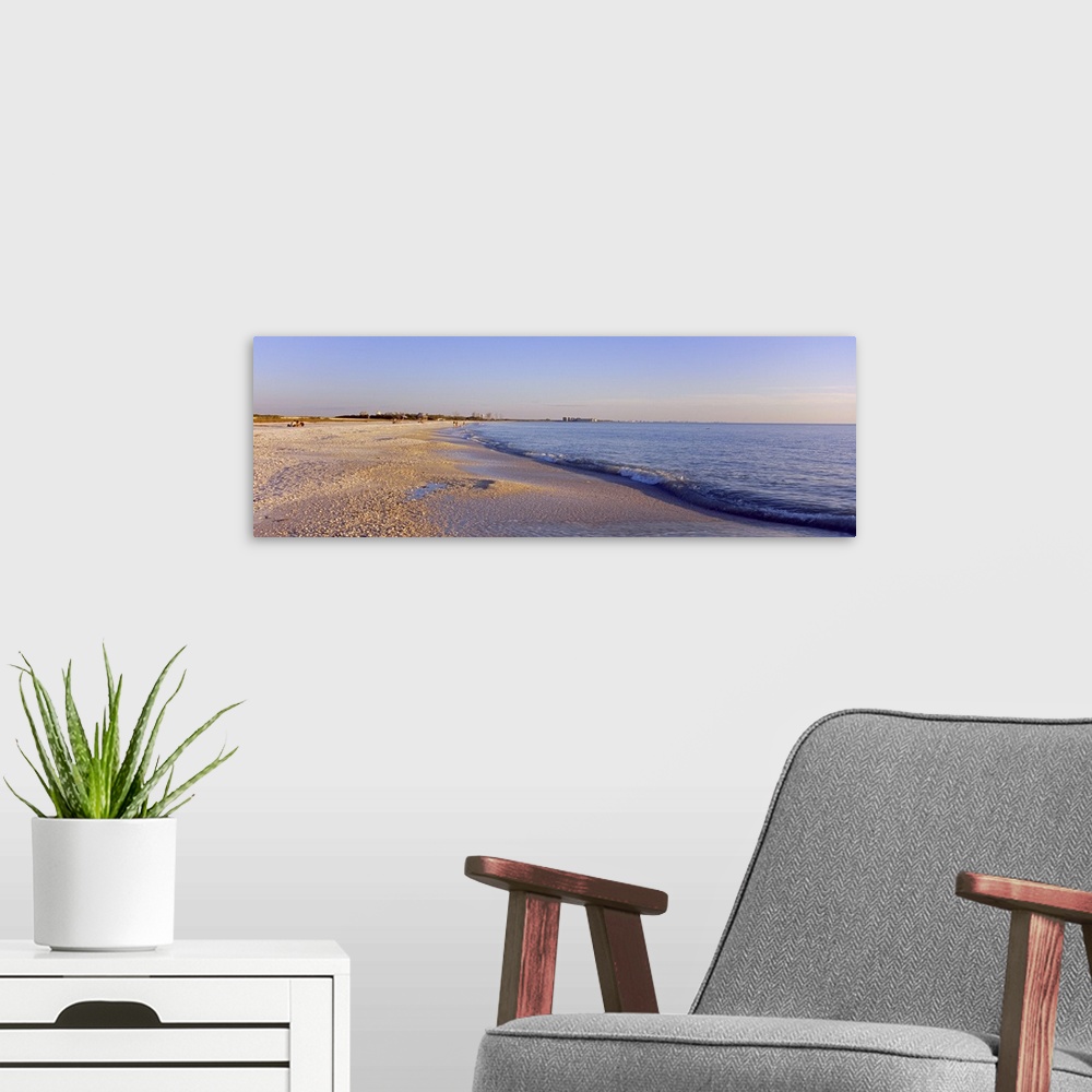 A modern room featuring Panoramic photograph looking down the shoreline of Fort Myers Beach beneath a blue sky, in the Gu...