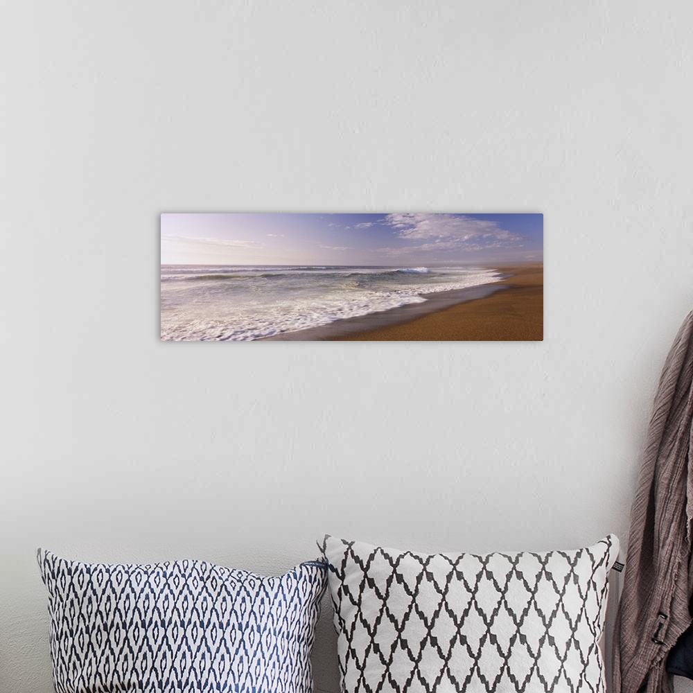 A bohemian room featuring A wide angle picture of the ocean as the water begins to rush up on the warm sand.