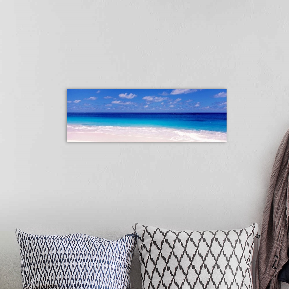 A bohemian room featuring Oversized wall hanging for the home this is a serene panoramic beach photograph of a calm sea ful...