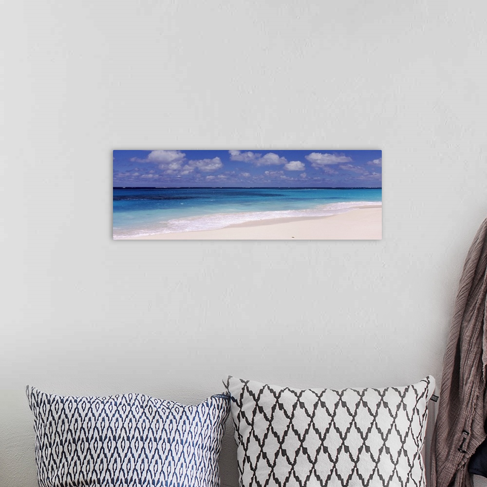 A bohemian room featuring Panoramic photograph of the ocean against the sand on a cloudy day at Shoal Bay Beach in Anguilla.