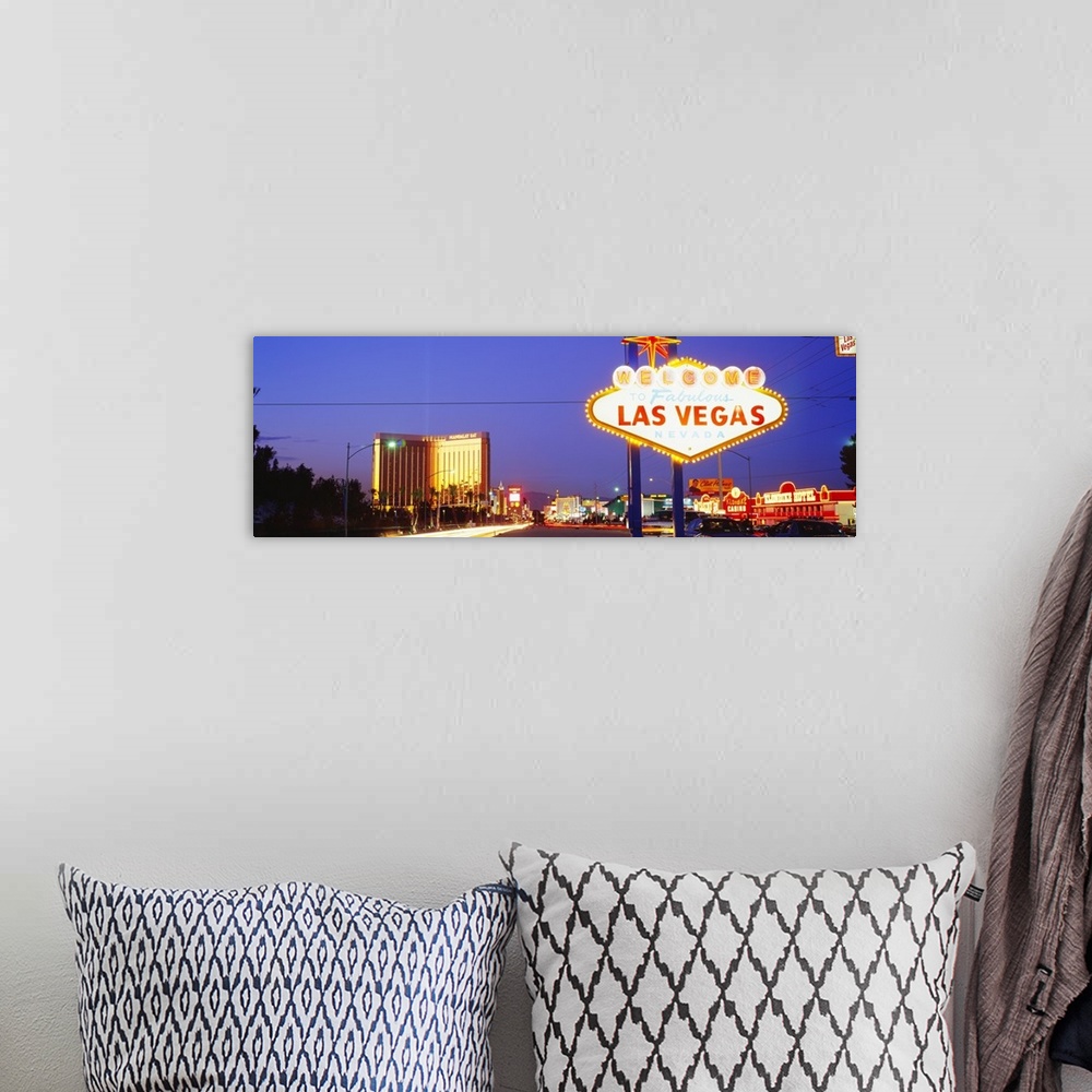 A bohemian room featuring Panoramic photograph of huge neon sign in ""Sin City"" with buildings lit up in the distance at d...