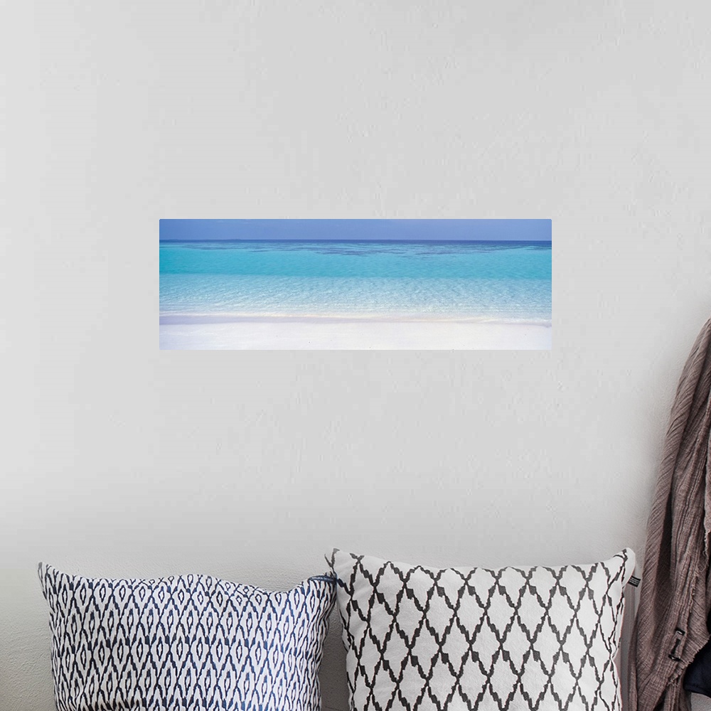 A bohemian room featuring This panoramic photograph shows clear tropical water creating ripples against the shore.