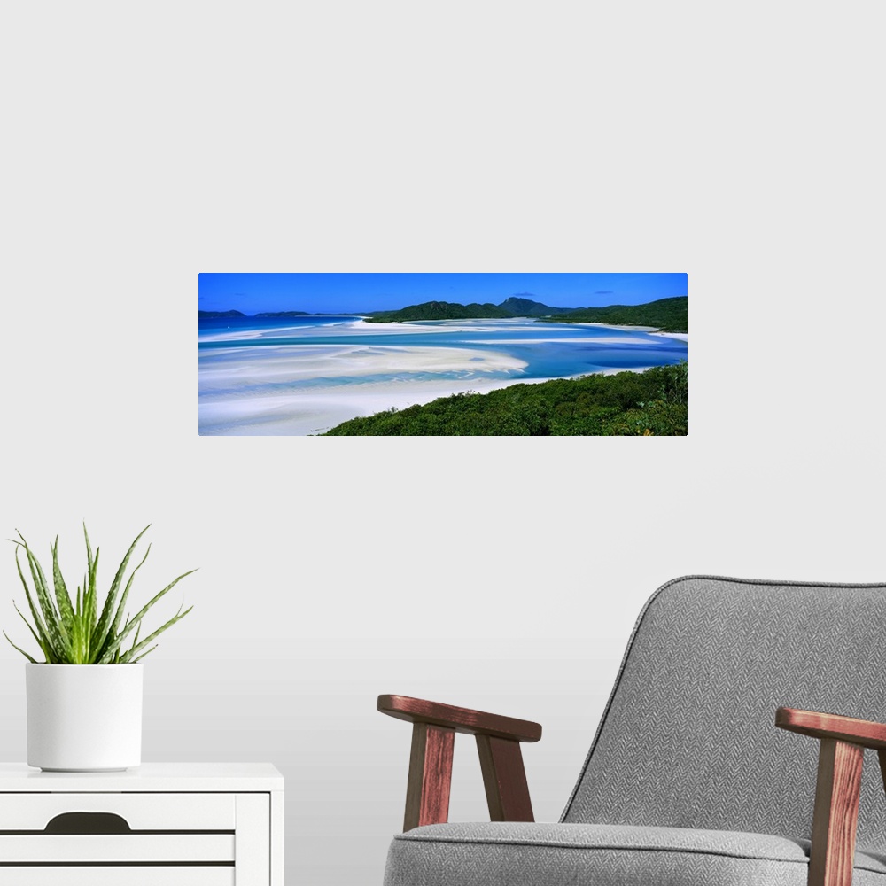 A modern room featuring Panoramic view of white beaches and water surrounded by hills and dense forest.
