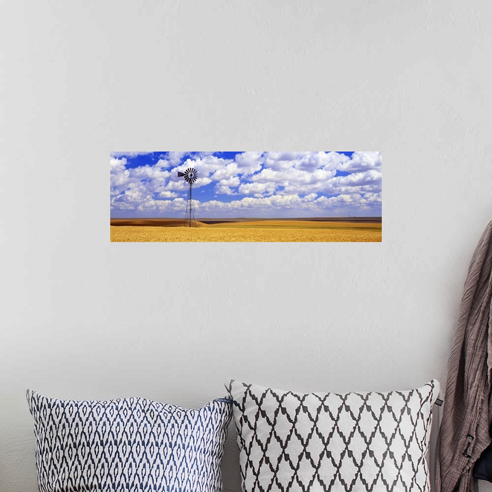 A bohemian room featuring Panoramic photograph of field with tall windmill under a cloudy sky.