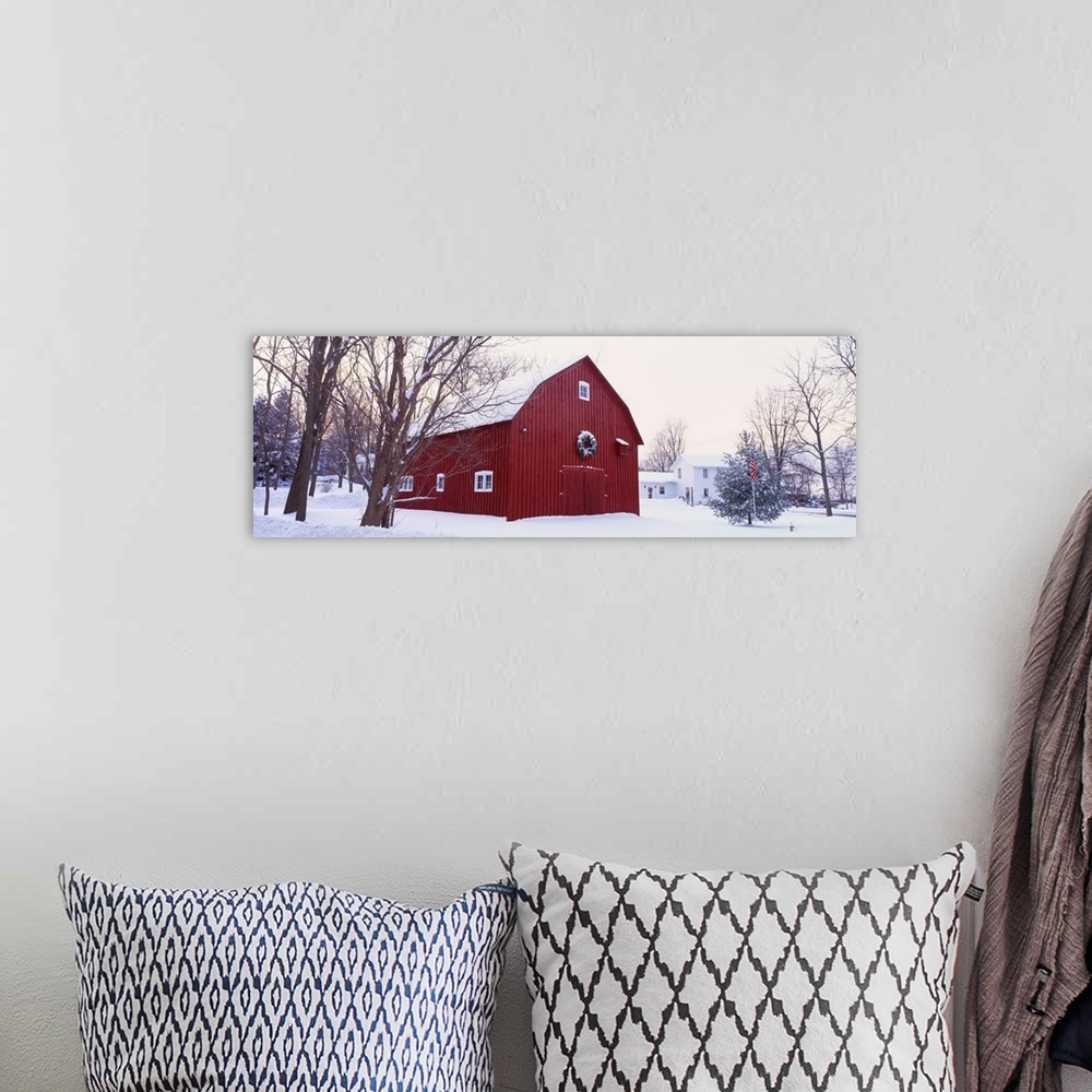 A bohemian room featuring Panoramic image print of a big barn in the middle of the snow with a wreath on it.