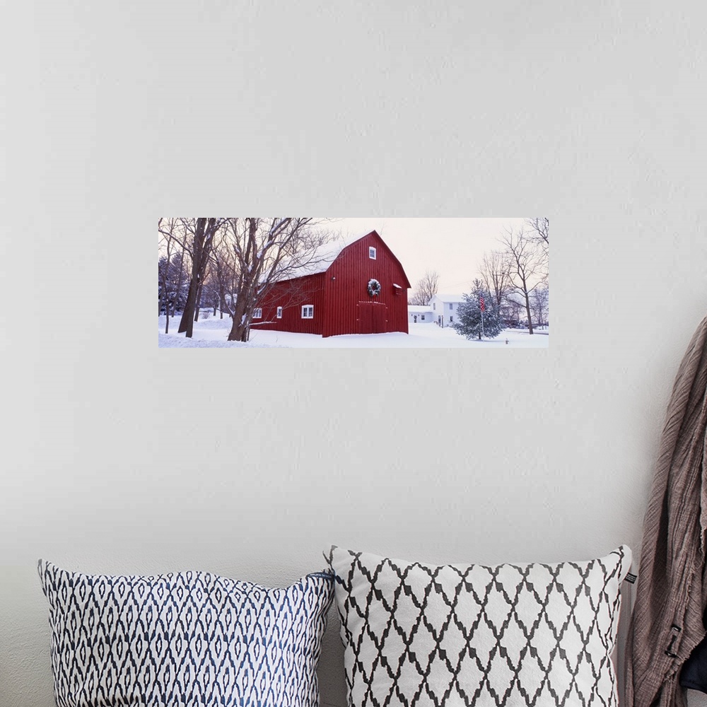A bohemian room featuring Panoramic image print of a big barn in the middle of the snow with a wreath on it.