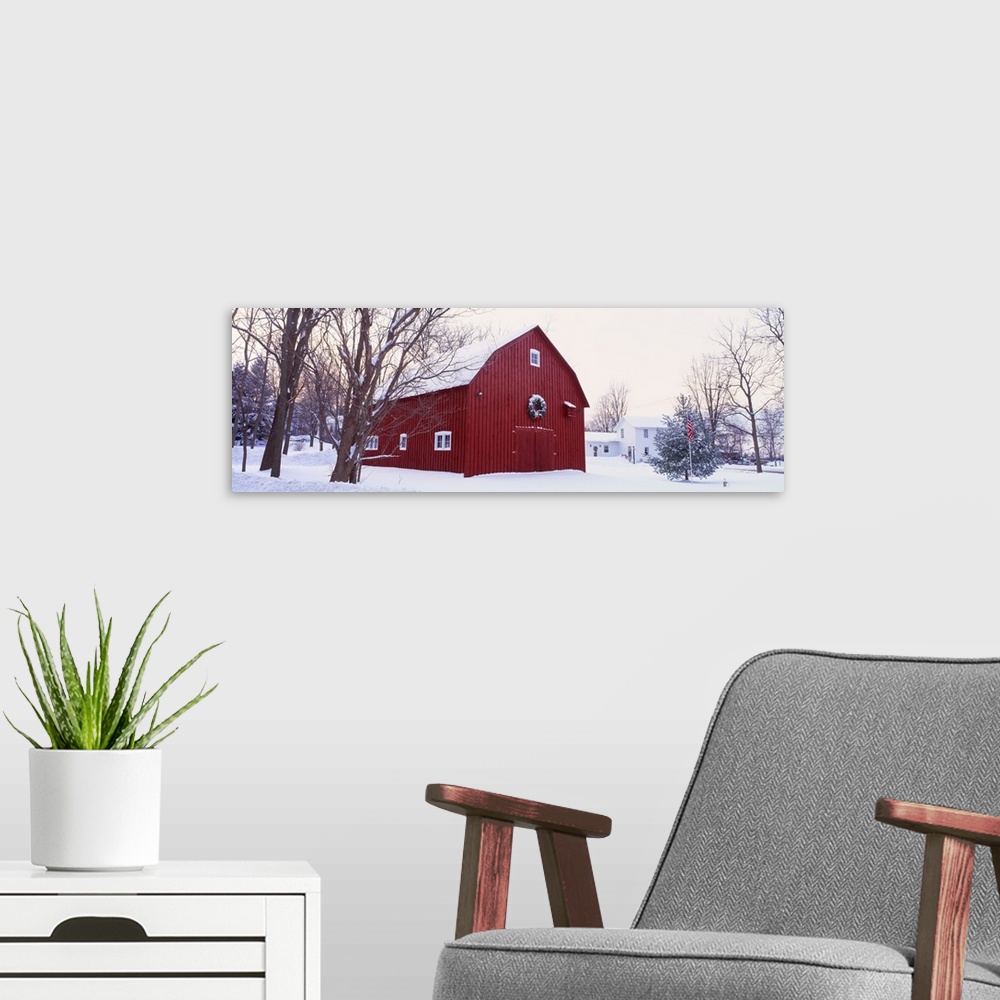 A modern room featuring Panoramic image print of a big barn in the middle of the snow with a wreath on it.