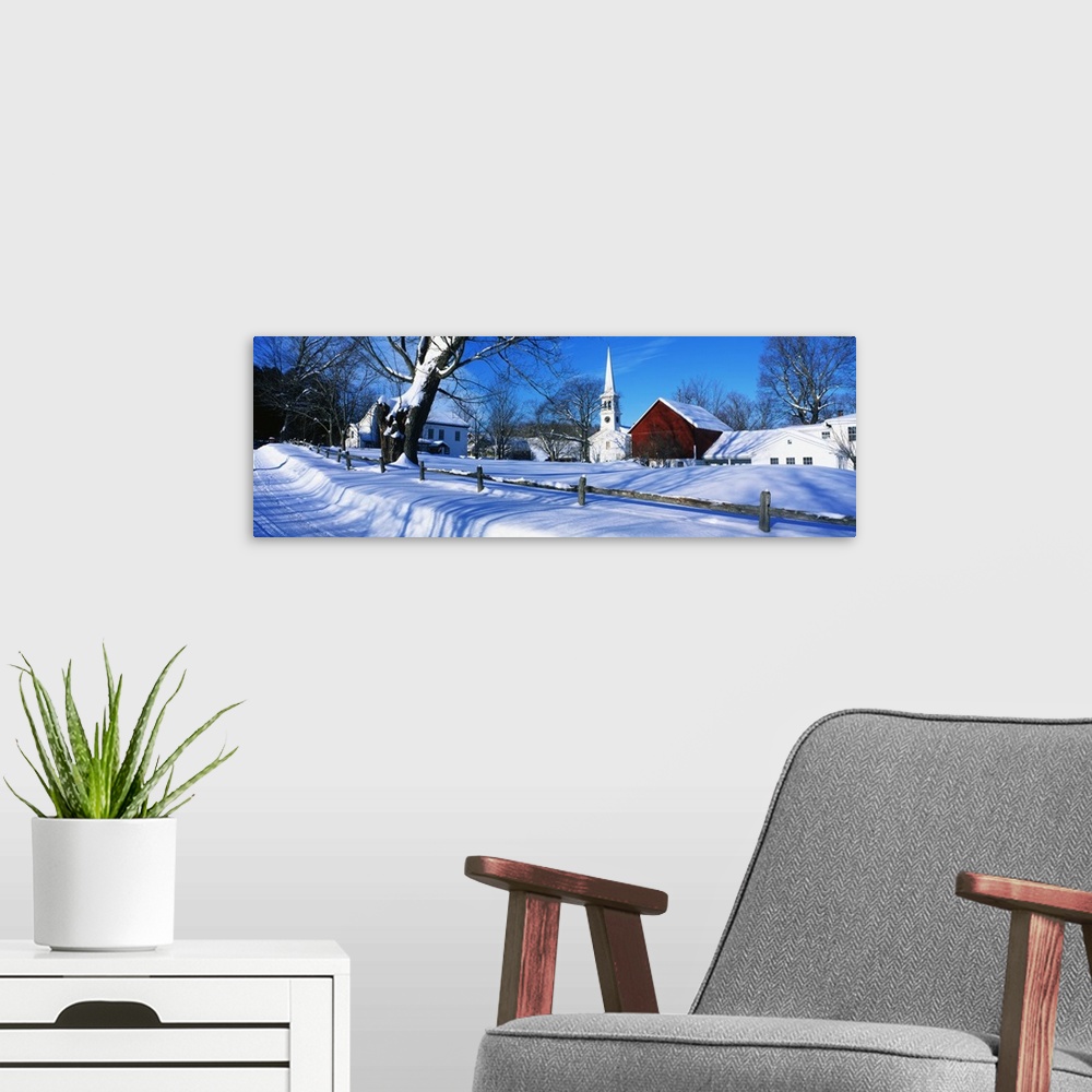 A modern room featuring Large, horizontal photograph of a snow covered landscape next to the road in Peacham, Vermont.  S...