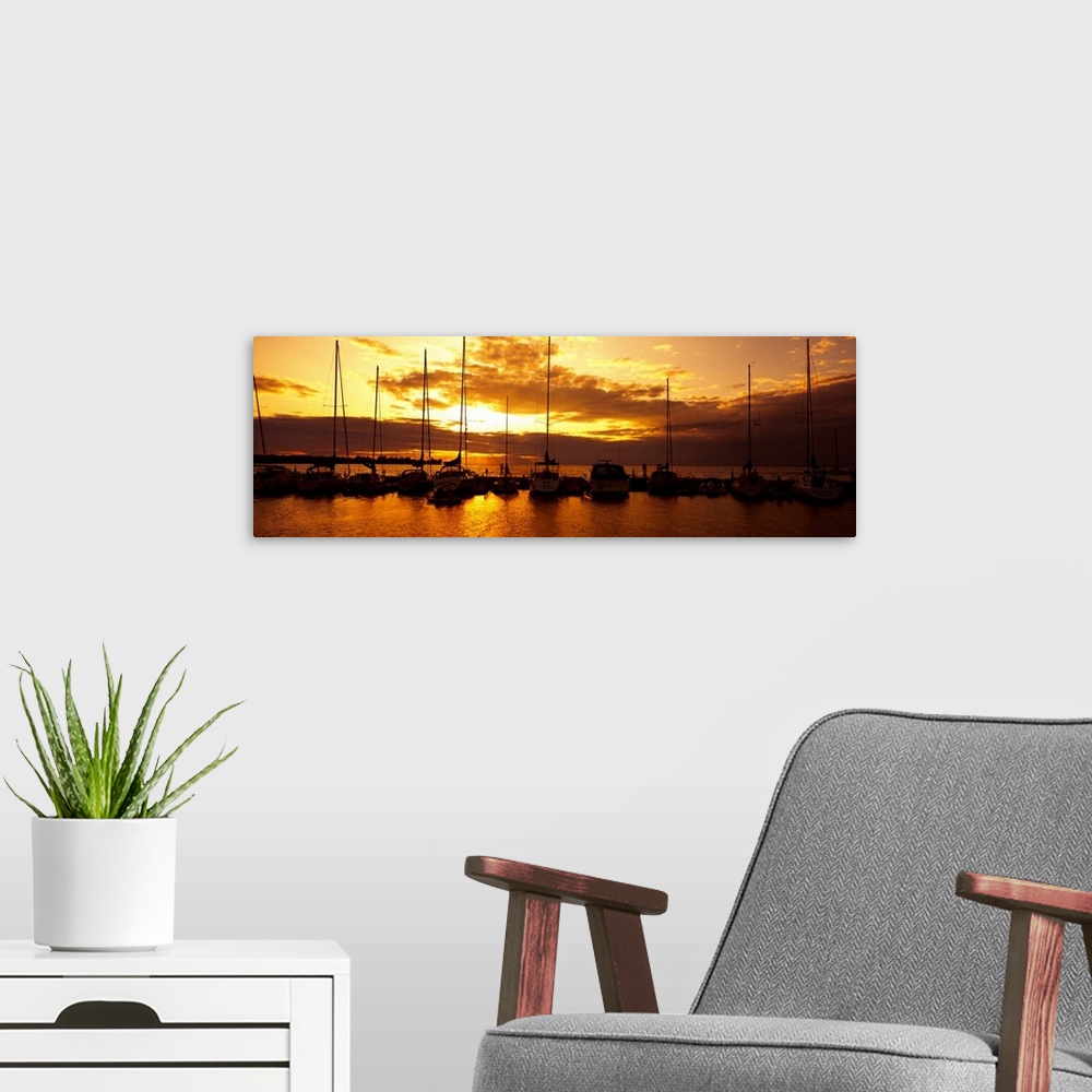 A modern room featuring Panoramic photograph of many boats in a line, docked in Egg Harbor beneath a vibrant setting sun,...