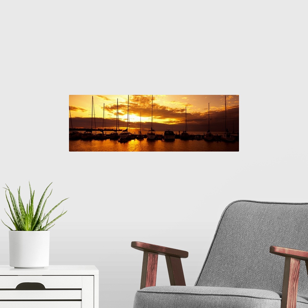 A modern room featuring Panoramic photograph of many boats in a line, docked in Egg Harbor beneath a vibrant setting sun,...
