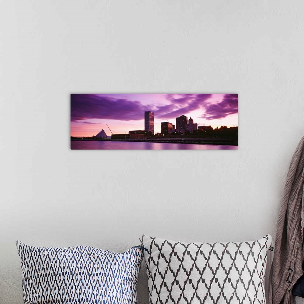 A bohemian room featuring Taken from on the water at sunset this panoramic photograph shows city skyscrapers built along th...