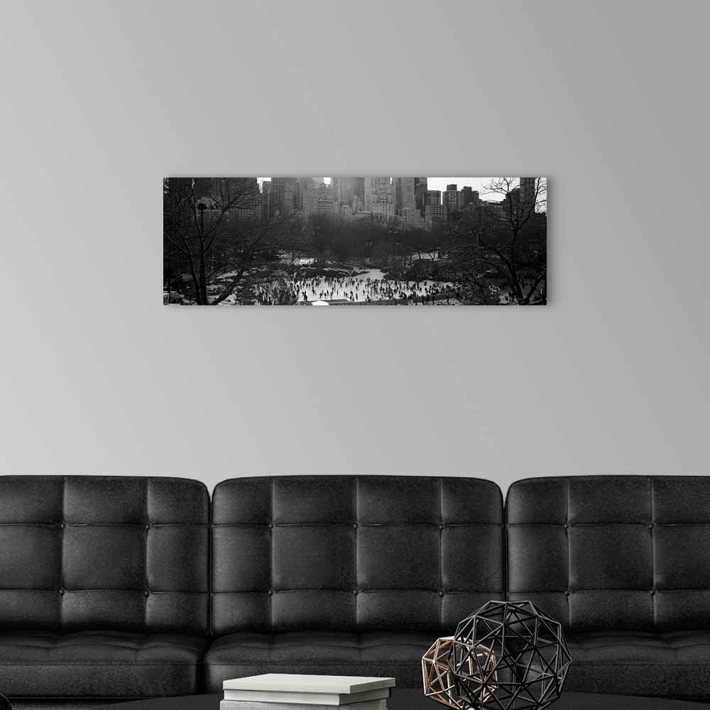 A modern room featuring Vintage black and white photograph of a frozen pond full of ice skaters in the winter in the cent...