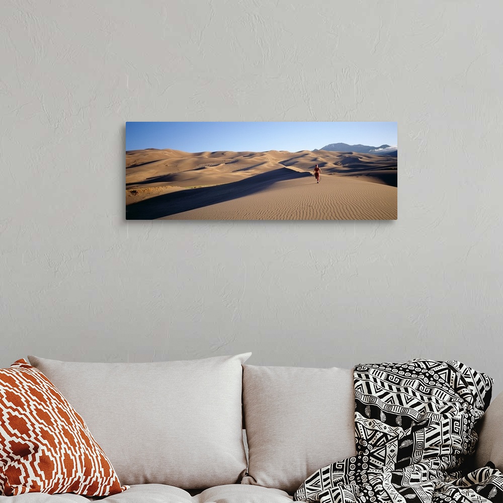 A bohemian room featuring Woman running in the desert, Great Sand Dunes National Monument, Colorado