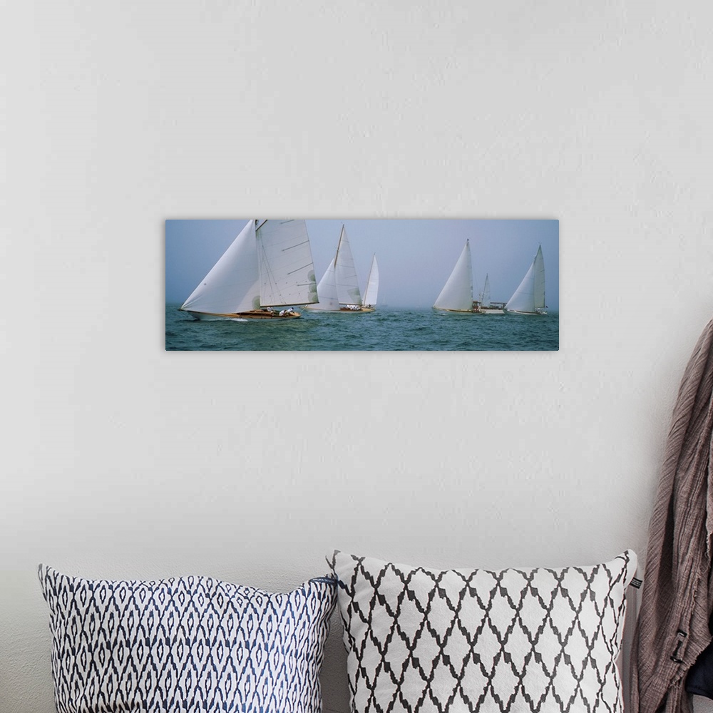 A bohemian room featuring Panoramic photograph of sailboats crossing the ocean on a clear day.