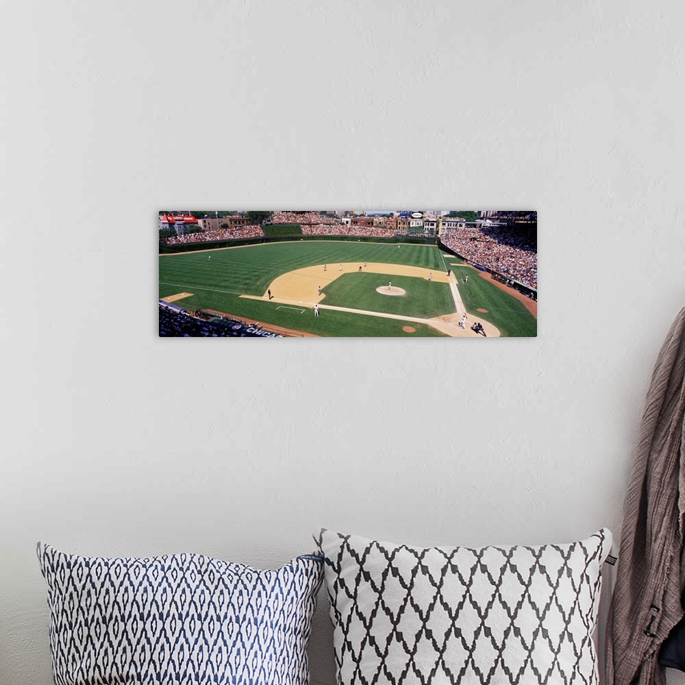 A bohemian room featuring A wide angle shot taken from above the Chicago Cubs baseball stadium during a day game.