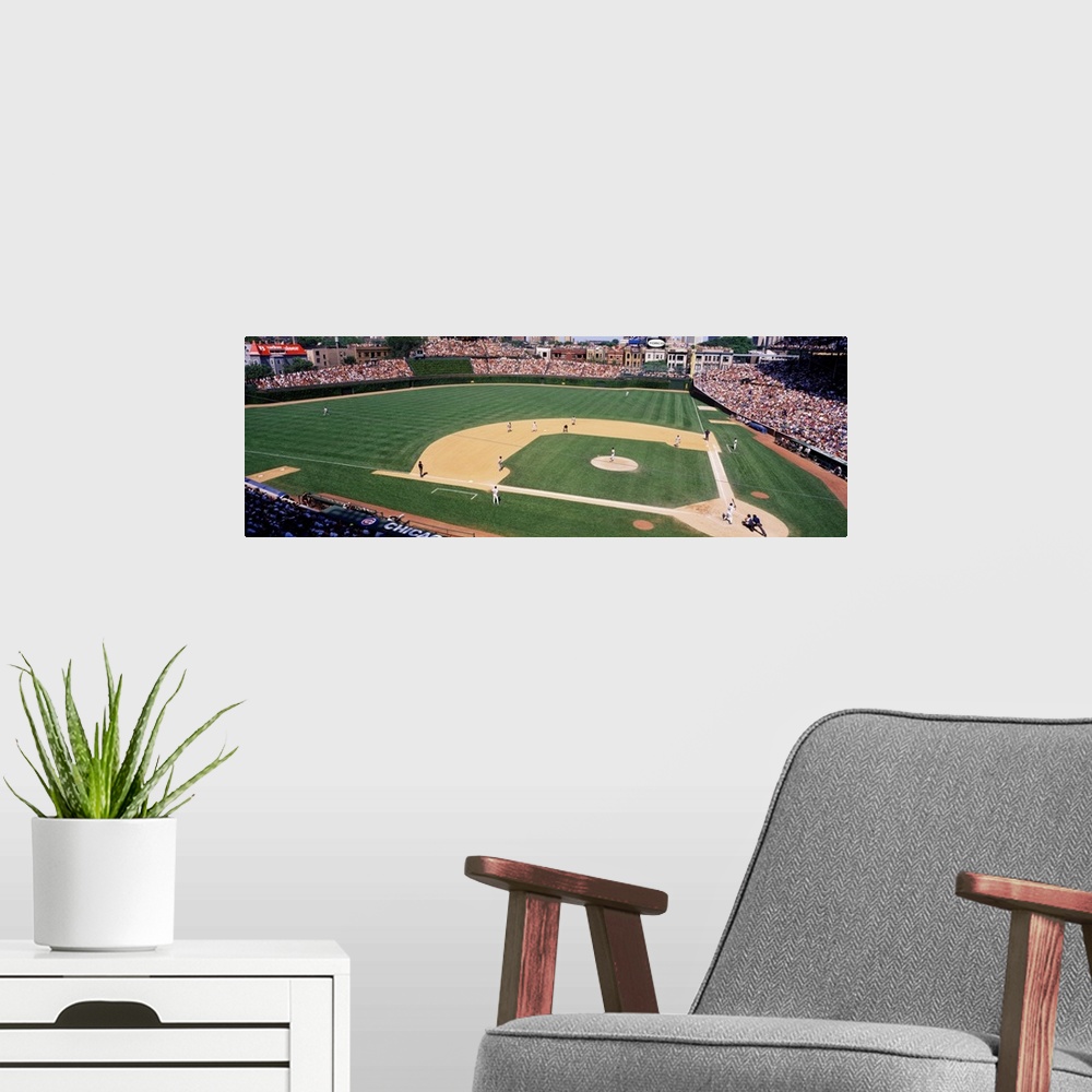 A modern room featuring A wide angle shot taken from above the Chicago Cubs baseball stadium during a day game.