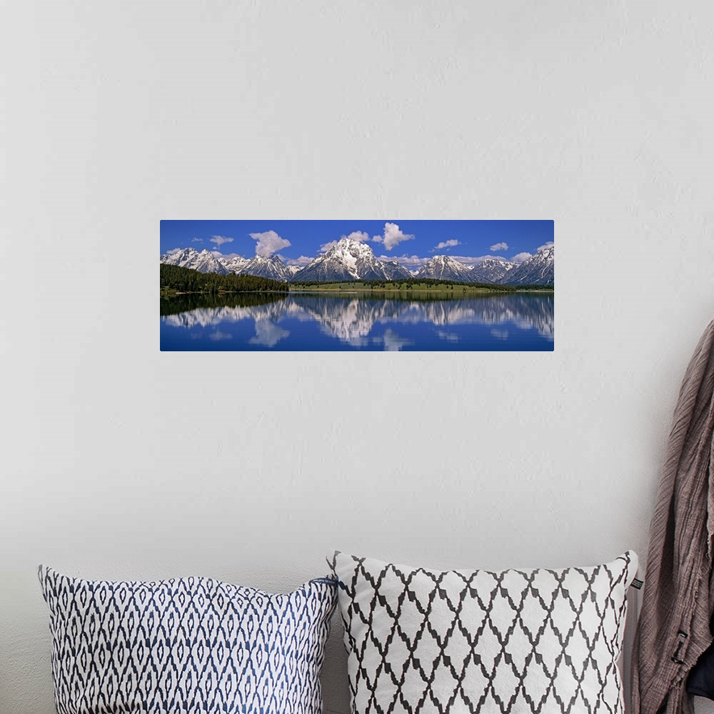 A bohemian room featuring Large panoramic photo of calm water with rugged snow capped mountains in the distance.