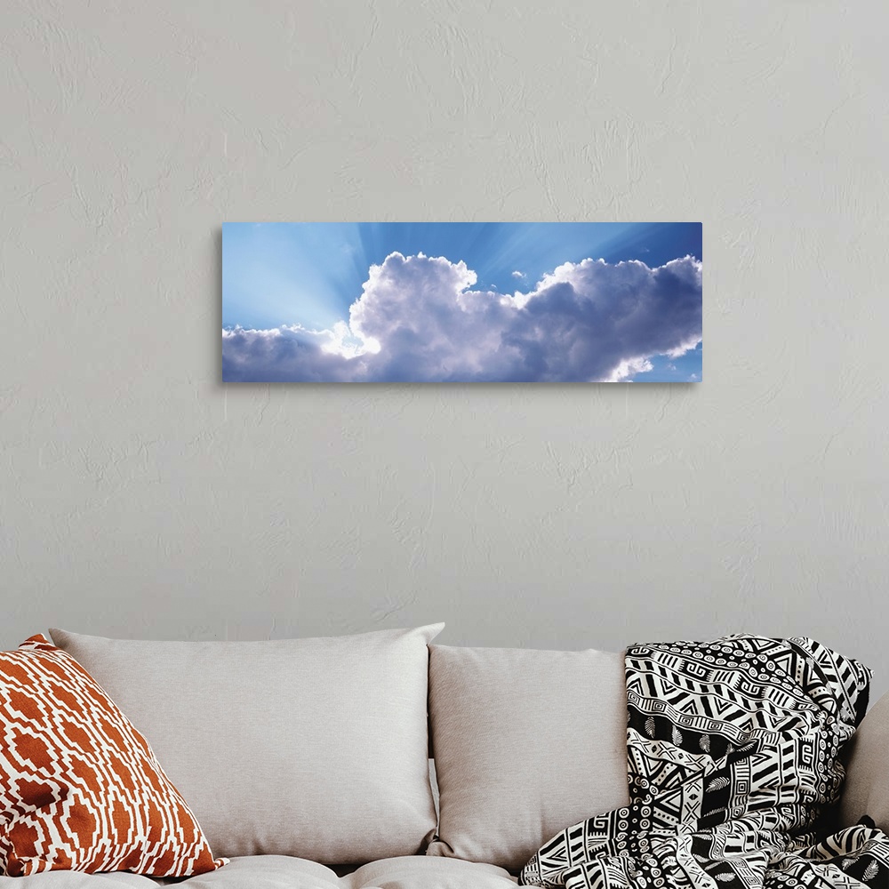 A bohemian room featuring This is a panoramic photograph looking up into a cluster of cumulus clouds and the sunlight radia...