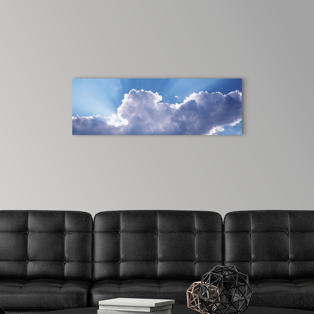 A modern room featuring This is a panoramic photograph looking up into a cluster of cumulus clouds and the sunlight radia...