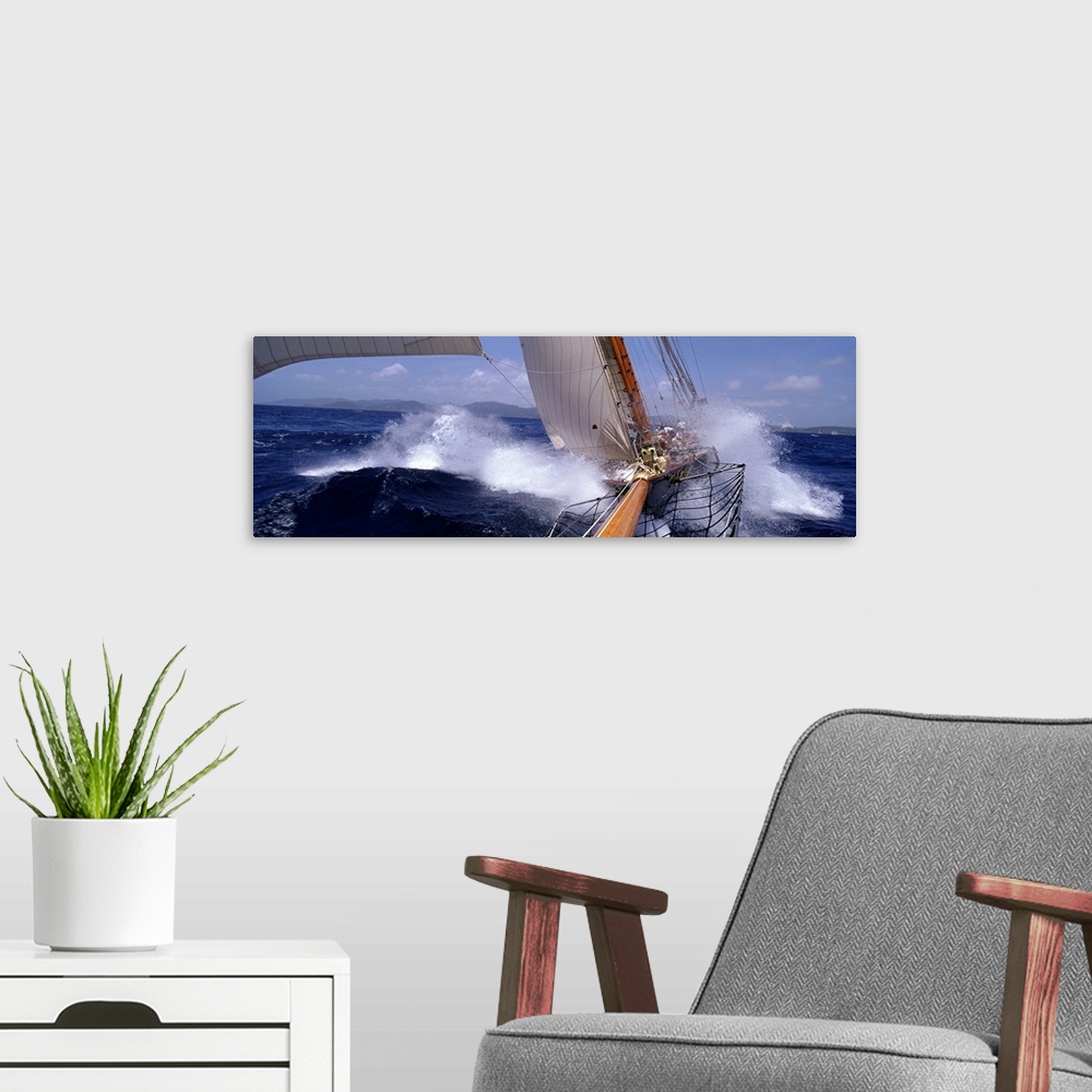 A modern room featuring Large, horizontal photograph of two yachts racing in rough waves of the Caribbean.  One boat is i...