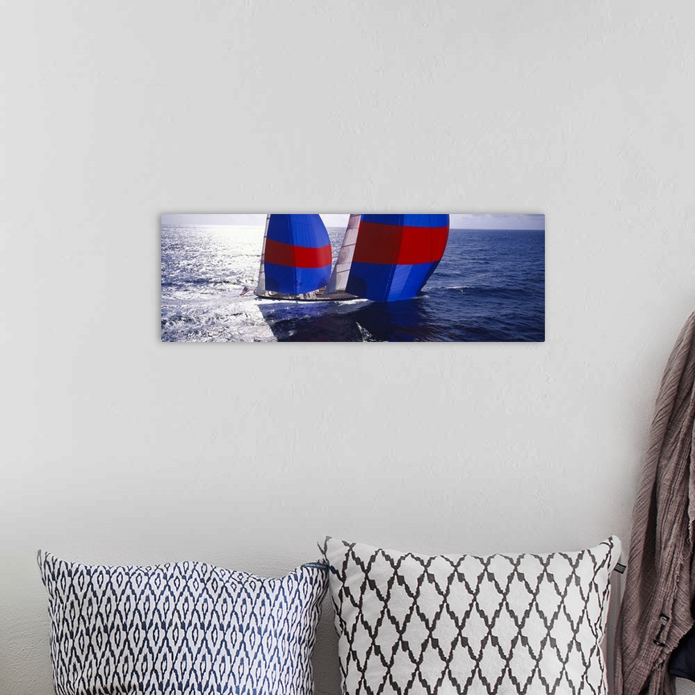 A bohemian room featuring Panoramic canvas of  a yacht sailing quickly through the ocean.