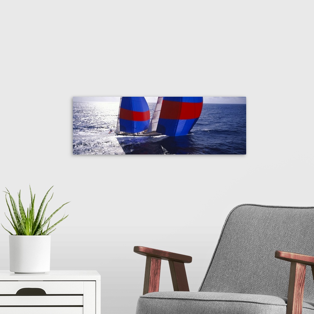 A modern room featuring Panoramic canvas of  a yacht sailing quickly through the ocean.