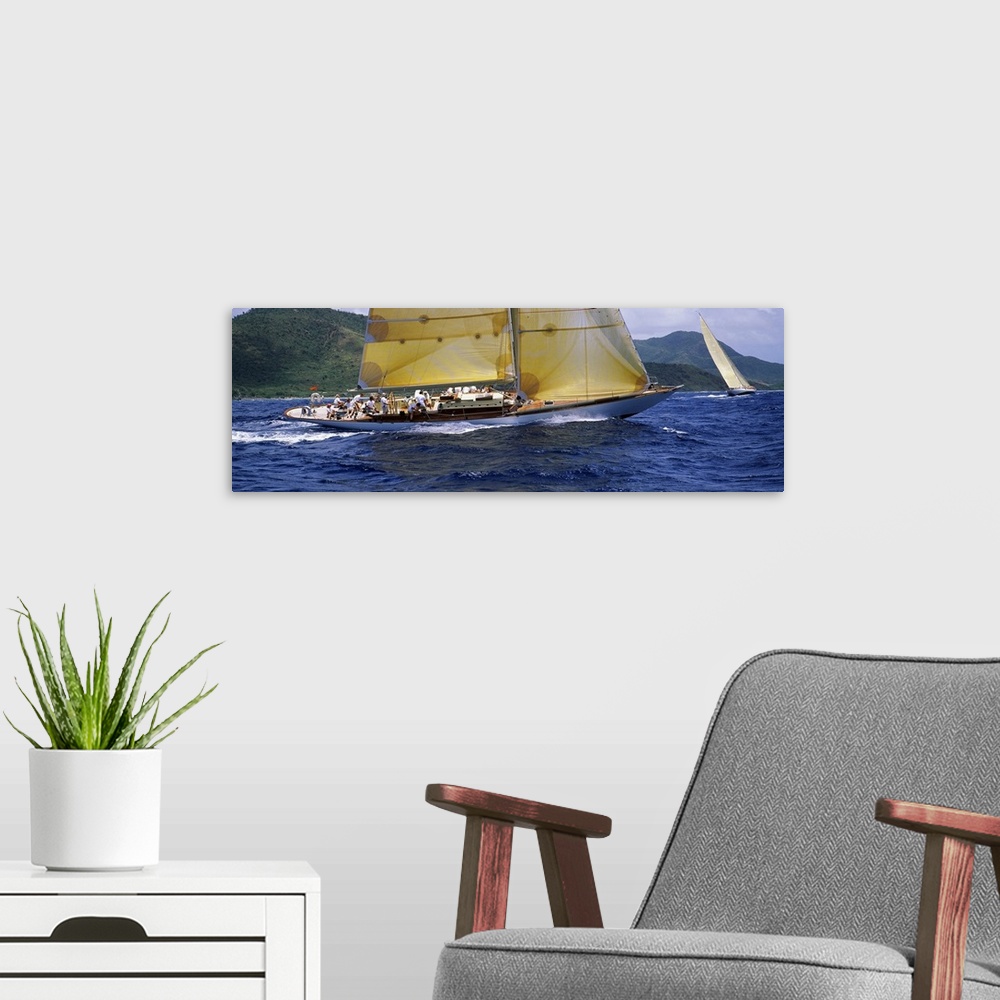 A modern room featuring A crowded yacht sails past a tropical island in the Caribbean in this landscape photograph.