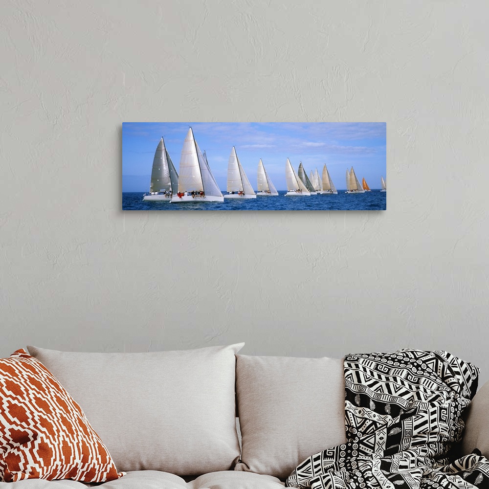 A bohemian room featuring Panoramic photograph taken of several yachts that are sitting in line with each other in the ocean.