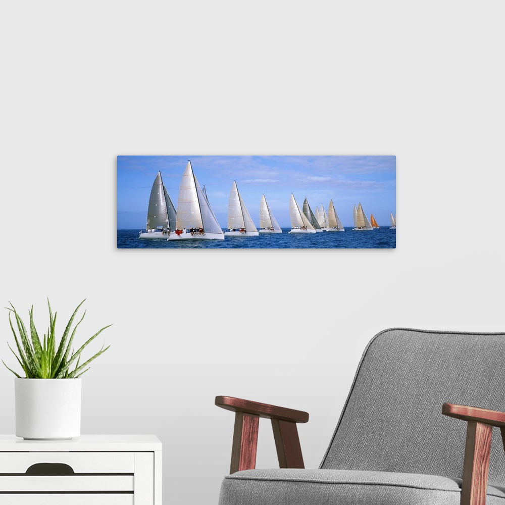 A modern room featuring Panoramic photograph taken of several yachts that are sitting in line with each other in the ocean.
