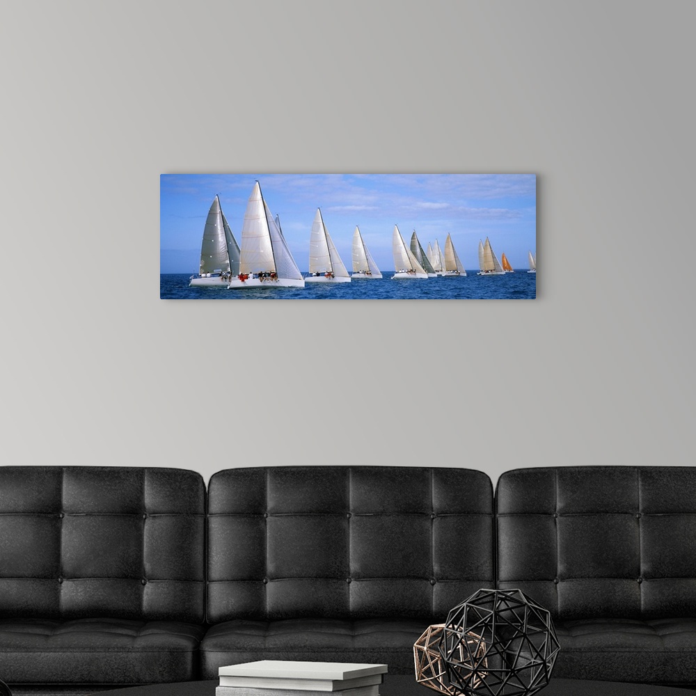 A modern room featuring Panoramic photograph taken of several yachts that are sitting in line with each other in the ocean.