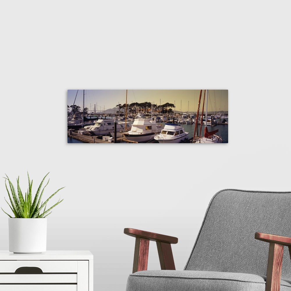 A modern room featuring Yachts moored at a harbor with a suspension bridge in the background, Golden Gate Bridge, Marina ...