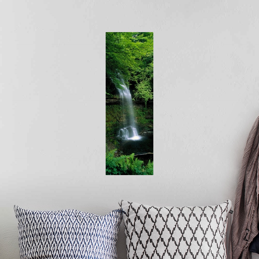 A bohemian room featuring Vertical panoramic photograph of water cascading over a tree covered cliff's edge down to a lagoon.