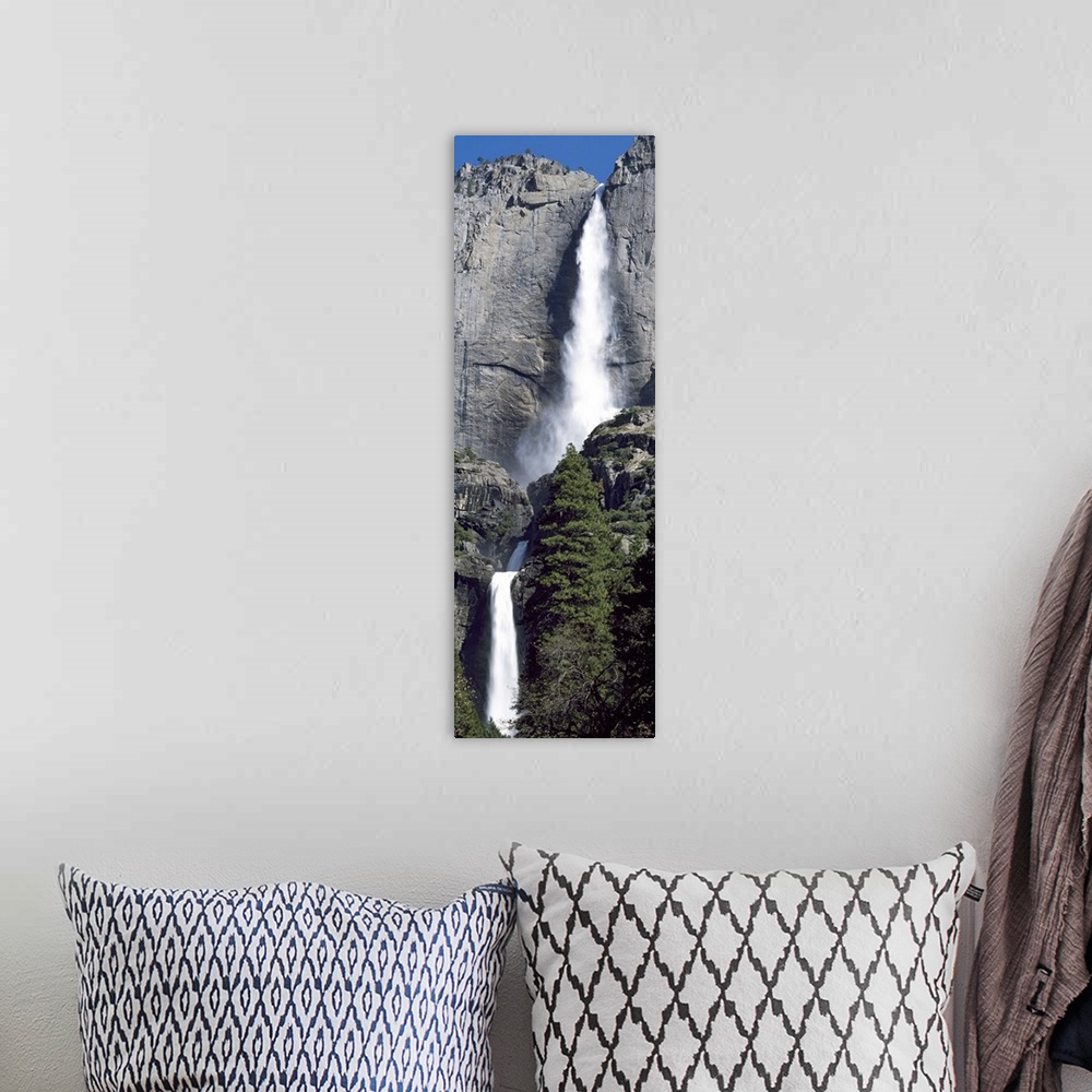 A bohemian room featuring A narrow and vertical shaped photograph of the majestic Yosemite Falls in late spring with heavy ...