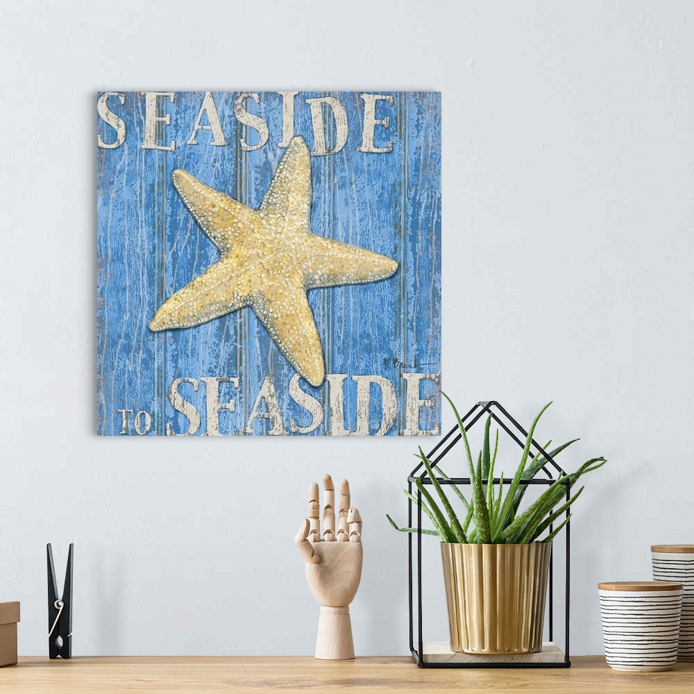 A bohemian room featuring Square painting of a starfish on blue wood panels with the text Seaside to Seaside.