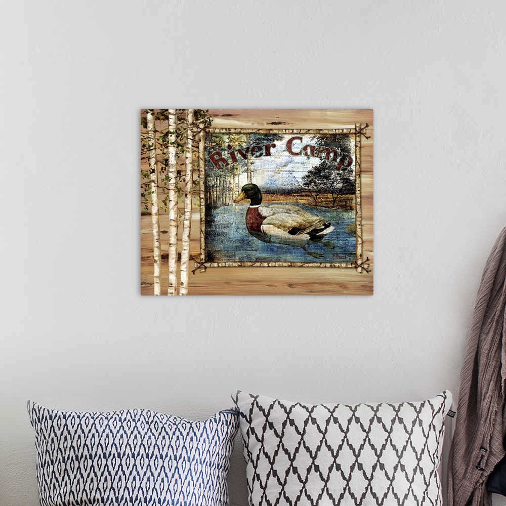 A bohemian room featuring Decorative artwork of a duck in a frame, with birch trees and the words River Camp.