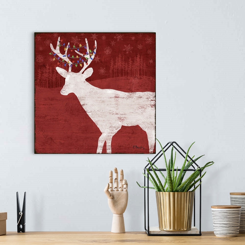 A bohemian room featuring White silhouette of a deer with lights in its antlers on a red forest backdrop.