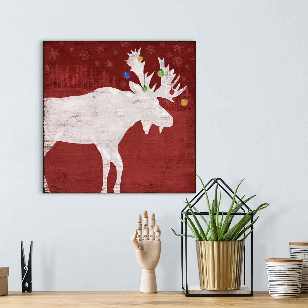 A bohemian room featuring White silhouette of a moose with ornaments on its antlers on a red forest backdrop.