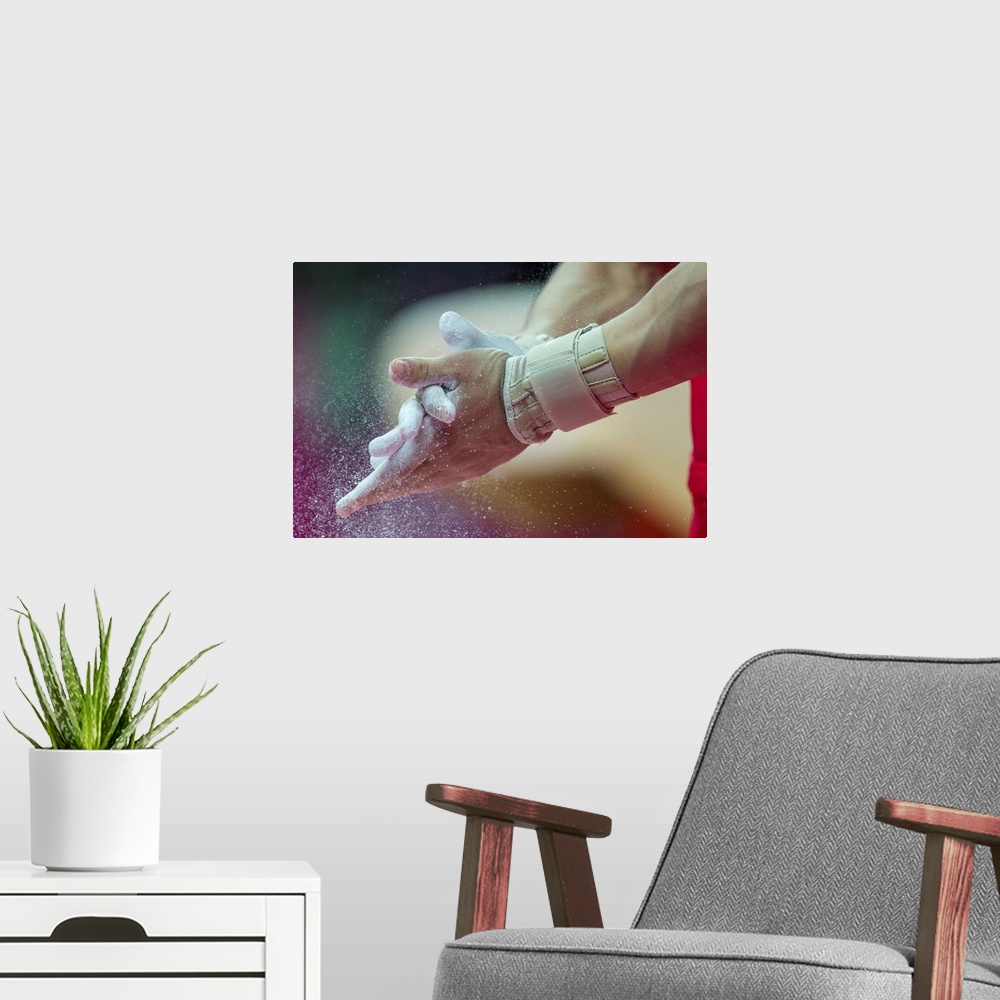A modern room featuring Detail of male gymnasts hands applying chalk during the Men's Gymnastics Individual All-Around at...