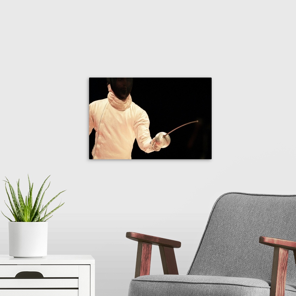 A modern room featuring Male fencer in action